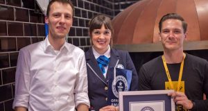 Stefan Marcinek (CEO Assemble Entertainment) und Nikolay Abrosov (General Manager Pizza.de) erhalten von der Guinness-Preisrichterin die Käsepizza-Weltrekord-Urkunde.