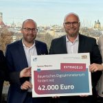 Annette Kümmel (Geschäftsführerin Medien.Bayern GmbH), MdL Felix Locke (Freie Wähler), Digitalminister Fabian Mehring (Freie Wähler) und Robin Rottmann (Team Lead Games Bavaria) bei der Scheckübergabe im bayerischen Landtag - Foto: StMD Bayern