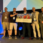 Scheck is back: Digitalminister Fabian Mehring mit dem Spaceflower-Team und Vertretern des FFF Bayern beim Bayerischen Digitalgipfel 2026 am 25. Juni in Nürnberg.