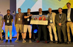 Spaceflower zahlt Games-Förderung für ‚Let Them Trade‘ zurück Scheck is back: Digitalminister Fabian Mehring mit dem Spaceflower-Team und Vertretern des FFF Bayern beim Bayerischen Digitalgipfel 2026 am 25. Juni in Nürnberg.